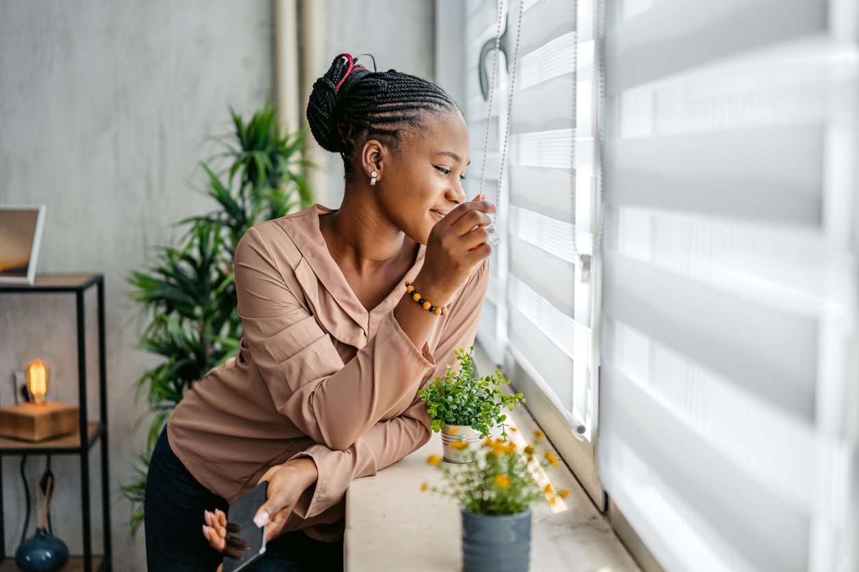 Blinds + Design - Woman looking through window